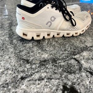 On Running Cream and Black Sneakers